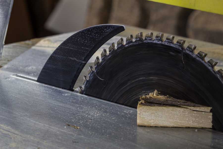 A riving knife mounted behind a table saw blade