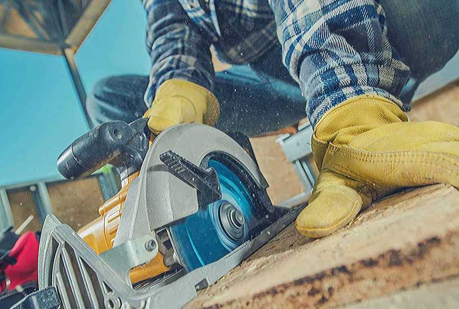 A worker uses a circular saw to cut lumber