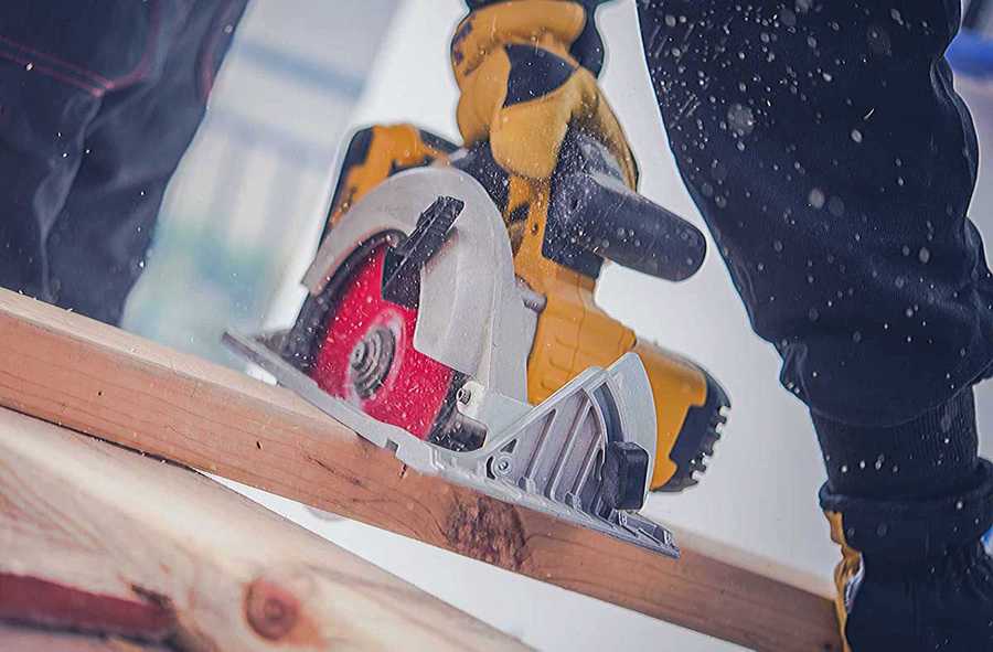 A worker uses a circular saw to cut a two-by-four